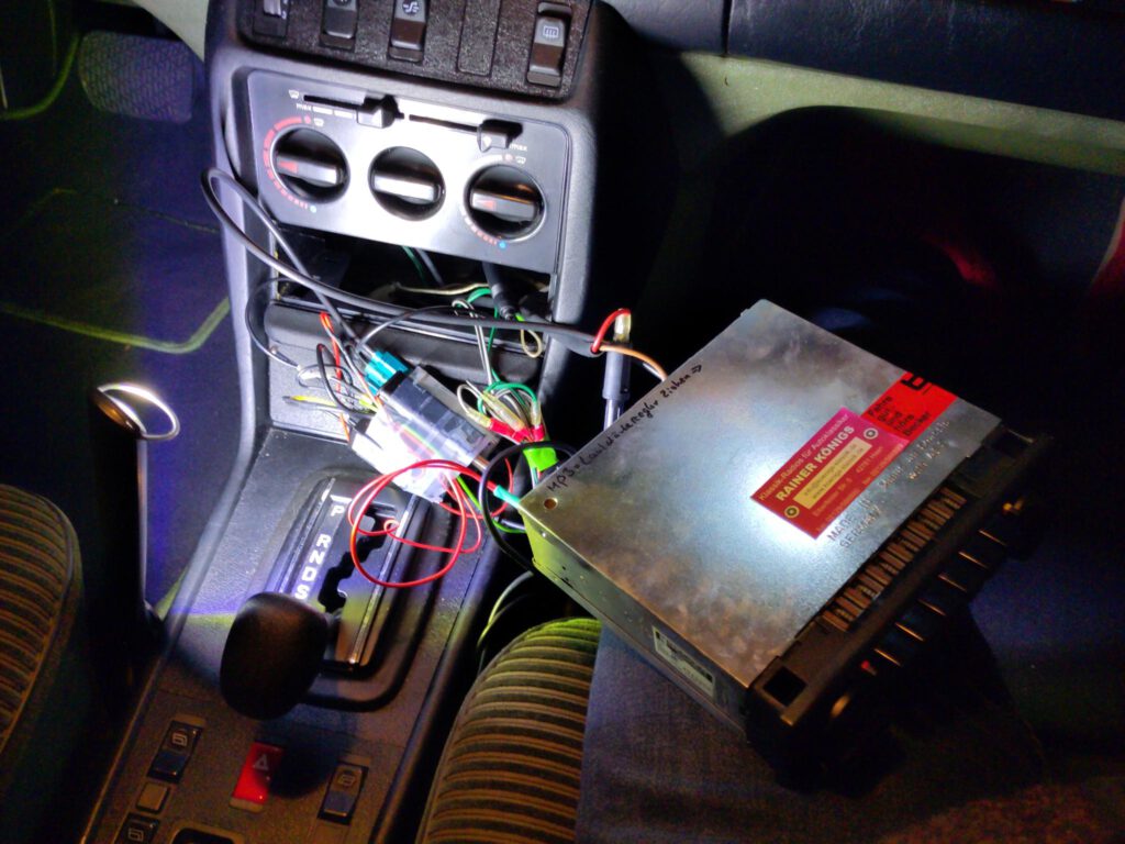 Benz-MIttelkonsole mit ausgebautem Radio und vielen Kabeln, sowie den zusätzlichen Geräten für die DAB-Aufrüstung